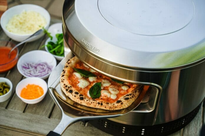 A Pizza Being Loaded in the Solo Stove Pi Prime Pizza Oven