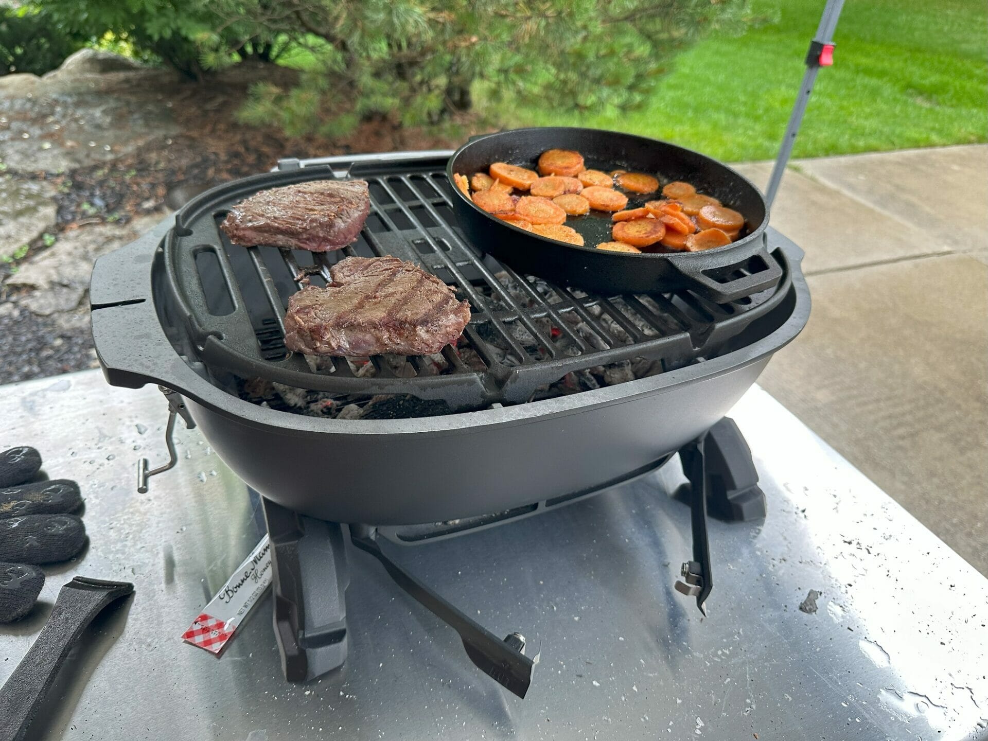 https://www.cookoutnews.com/wp-content/uploads/2023/08/Steaks-and-a-Cast-Iron-Pan-on-a-PK-Grills-PKGO-Hibachi-Grill.jpg