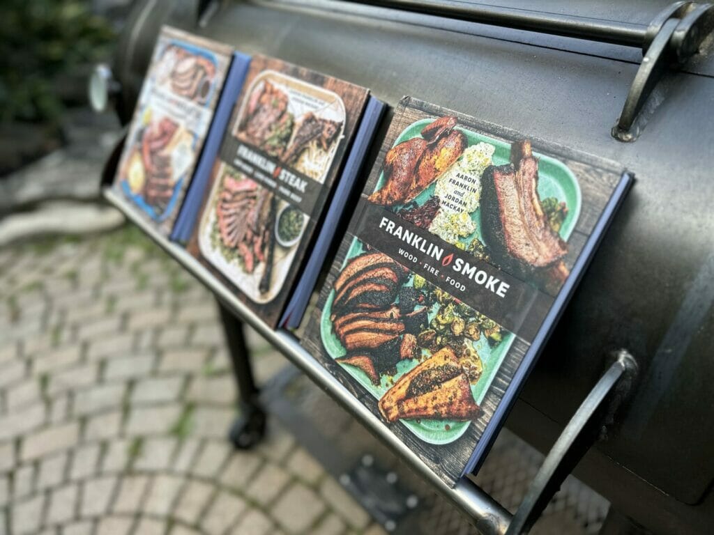 All Three Aaron Franklin Books on a Franklin Barbecue Pit