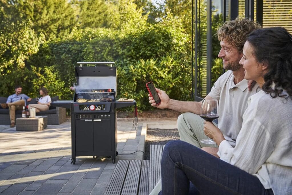 Char-Broil EVOLVE Connected Gas Grill - Couple Using App