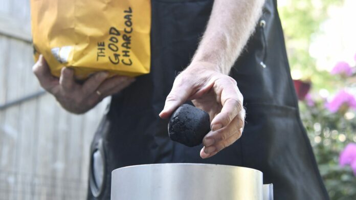 The Good Charcoal Briquettes Being Loaded Into a Chimney